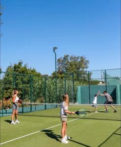 a group of people playing tennis on a tennis court at St Tropez Surprise in Gassin