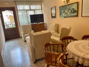 a living room with a table and chairs and a television at Hostal i Apartaments Populetus in Poboleda