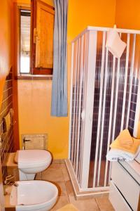 a bathroom with a toilet and a shower at Beautiful apartment surrounded by greenery in Chiaramonti +6 photos