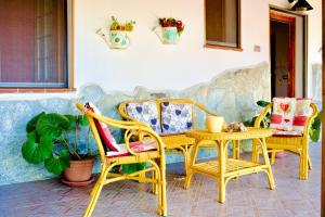 a patio with chairs and a table and a couch at Beautiful apartment surrounded by greenery in Chiaramonti