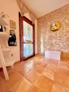 a room with a window and a tiled floor at Beautiful apartment surrounded by greenery in Chiaramonti