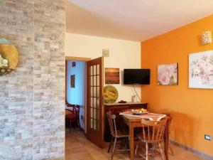 a living room with a table and a television at Beautiful apartment surrounded by greenery in Chiaramonti