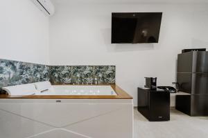 a kitchen with a bath tub and a refrigerator at Holiday burrone in Favignana