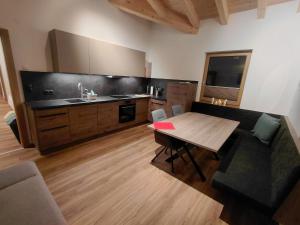 a kitchen with a wooden table and a wooden floor at Apart Monte Vista in Längenfeld