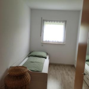 a small room with a bed and a window at Ferienwohnung Weber in Mühlau