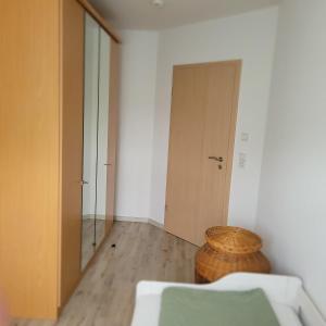 an empty room with a door and a wicker stool at Ferienwohnung Weber in Mühlau
