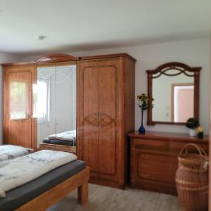 a bedroom with a wooden cabinet and a mirror at Ferienwohnung Weber in Mühlau