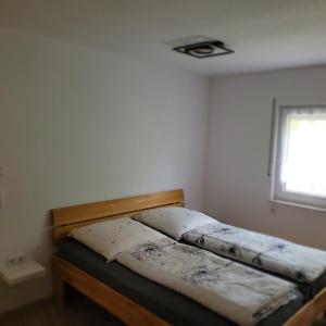 a twin bed in a room with a window at Ferienwohnung Weber in Mühlau