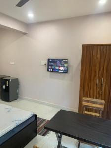 a room with a table and a tv on the wall at Aasra Studios in Agonda