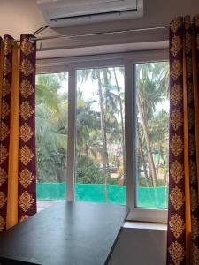 a room with a large window with a view of a pool at Aasra Studios in Agonda