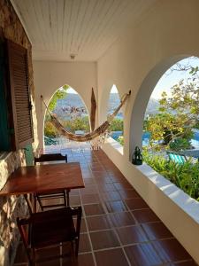 a room with a table and chairs and a hammock at Casa Dos Arcos Bed and Breakfast in Arraial do Cabo
