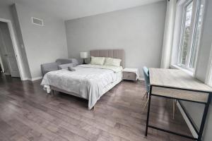 a white bedroom with a bed and a couch at Quiet Private Master Suite w Ensuite Great Value in Bélanger