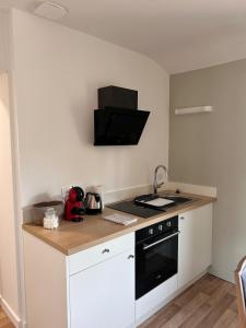 a kitchen with a sink and a stove top oven at L'escapade in Pont-de-Veyle