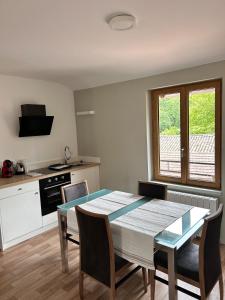 a kitchen with a table and chairs in a room at L'escapade in Pont-de-Veyle