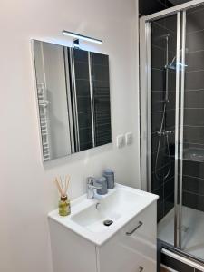 a white bathroom with a sink and a shower at L'escapade in Pont-de-Veyle