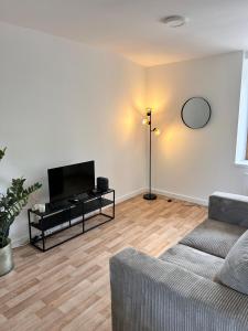 a living room with a couch and a flat screen tv at L'escapade in Pont-de-Veyle