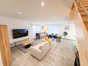 a living room with a couch and a table at Les oiseaux, maison de 3 chambres et climatisation in Montauban
