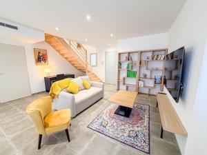 a living room with a couch and a table at Les oiseaux, maison de 3 chambres et climatisation in Montauban