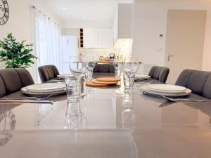 a dining room table with glasses and plates on it at Les oiseaux, maison de 3 chambres et climatisation in Montauban +32 photos