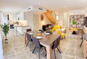 a dining room and living room with a table and chairs at Les oiseaux, maison de 3 chambres et climatisation in Montauban