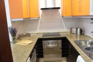 a kitchen with orange cabinets and a sink at Alojamento Bem-me-quer in Reguengos de Monsaraz