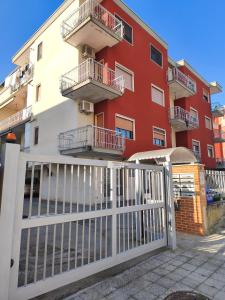 a red building with a white fence in front of it at TERRA DI SUD Matera - Free secure parking in Matera