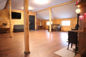 a large living room with wooden floors and a tv at Jaunmežu pirts in Rūstuži