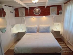 a bedroom with a bed with two pillows and a clock at Apartamento Villa Amanecer in Villarrica