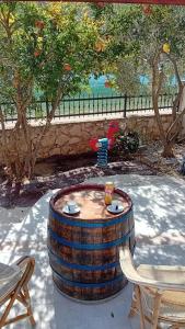 a barrel table in a yard with two chairs at Apartments Bulovic Bozo Ap1 in Podglavica