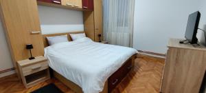 ein Schlafzimmer mit einem Bett und einem Fernseher in der Unterkunft La Muzeu in Tîrnăveni + 2 Fotos
