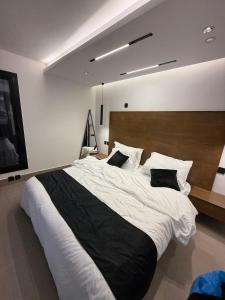 a bedroom with a large bed with white sheets and pillows at Wadi Hanifa View وادي حنيفة ڤيو in Riyadh