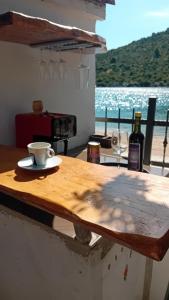 a table with a cup of coffee and a bottle of wine at Apartments Bulovic Bozo Ap1 in Podglavica