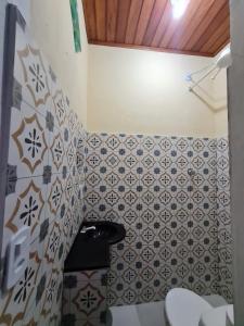 a small bathroom with tiles on the wall at Studio - Casa da Restinga in Cabo Frio