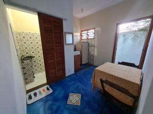 a room with a bed and a bathroom with a window at Studio - Casa da Restinga in Cabo Frio