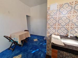 a room with a table and a blue floor at Studio - Casa da Restinga in Cabo Frio
