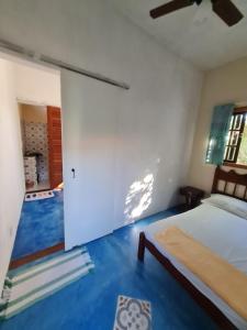 a bedroom with a bed and a blue floor at Studio - Casa da Restinga in Cabo Frio