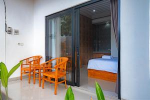 a room with two chairs and a bed and sliding glass doors at Sundara Haven in Ungasan