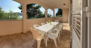 a dining room with a table and chairs and windows at Coastal dream in Razvala