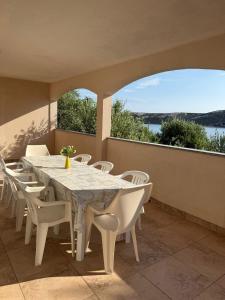 a white table and chairs on a balcony with a view at Coastal dream in Razvala