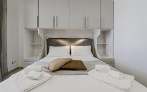a bedroom with a white bed with white cabinets at Holiday burrone in Favignana