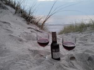 two glasses of wine in the sand on the beach at Ferienwohnung Birklund in Probsteierhagen +61 photos
