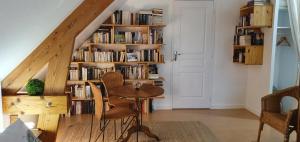 a room with a staircase with a book shelf with books at Maison des Hortensias in Saint-Contest