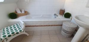 a white bathroom with a tub and a sink at Maison des Hortensias in Saint-Contest +7 photos