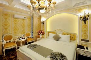 a bedroom with a large white bed and a chandelier at Violet hotel 2 in Nha Trang +61 photos