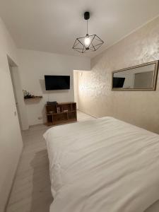 a bedroom with a white bed and a flat screen tv at Cleo Residence 1 Ghiroda in Ghiroda