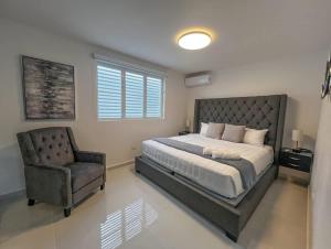 a bedroom with a large bed and a chair at Isabela Luxury Escape sky view in Isabela