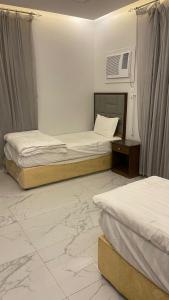 a room with two beds in a room with at شقق مخدومه in Ash Shafa