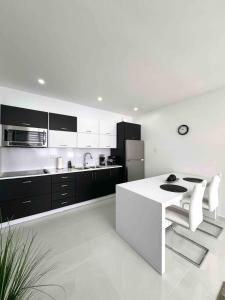 a white kitchen with a white table and a refrigerator at Isabela Luxury Escape Serenity in Isabela +16 photos