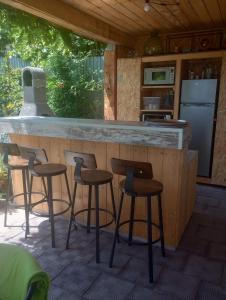 a kitchen with a counter with stools at a bar at Vila Georgeta, Camere de închiriat in Techirghiol