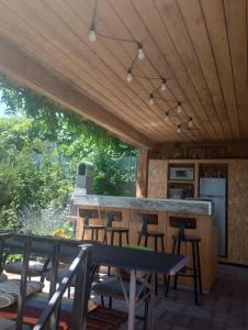 an outdoor kitchen with a bar and some chairs at Vila Georgeta, Camere de închiriat in Techirghiol